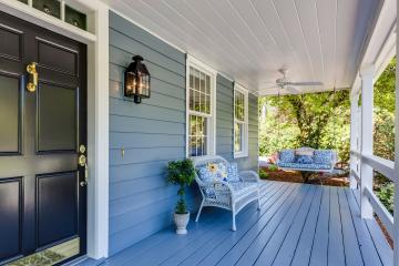 A view of a finished front porch with a white swing